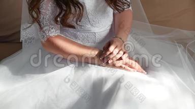 新娘`早上。 好艺术婚礼。 新娘的双手特写躺在白色的室内礼服上，婚礼的概念